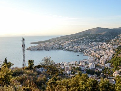 Panoramisch uitzicht op Sarandë aan de Ionische Zee, Albanië, met baai, stad en heuvels.