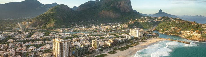 Barra Da Tijuca in Rio de Janeiro met strand, golven en bergen op de achtergrond.
