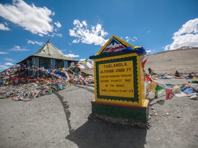 Bord bij de Taglang La-bergpas met kleurrijke gebedsvlaggen langs de Route Spiti & Ladakh.