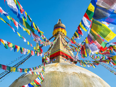 Gouden boeddhistische stoepa met kleurrijke gebedsvlaggen in Kathmandu, Nepal, tijdens de Annapurna Basecamp groepsrondreis.
