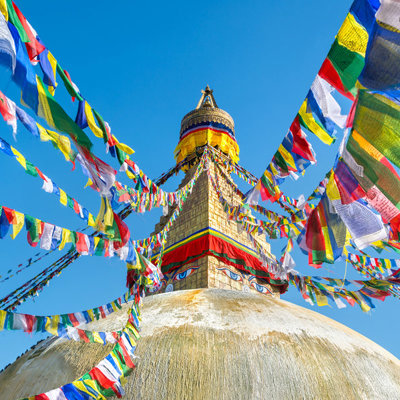 Gouden boeddhistische stoepa met kleurrijke gebedsvlaggen in Kathmandu, Nepal, tijdens de Annapurna Basecamp groepsrondreis.