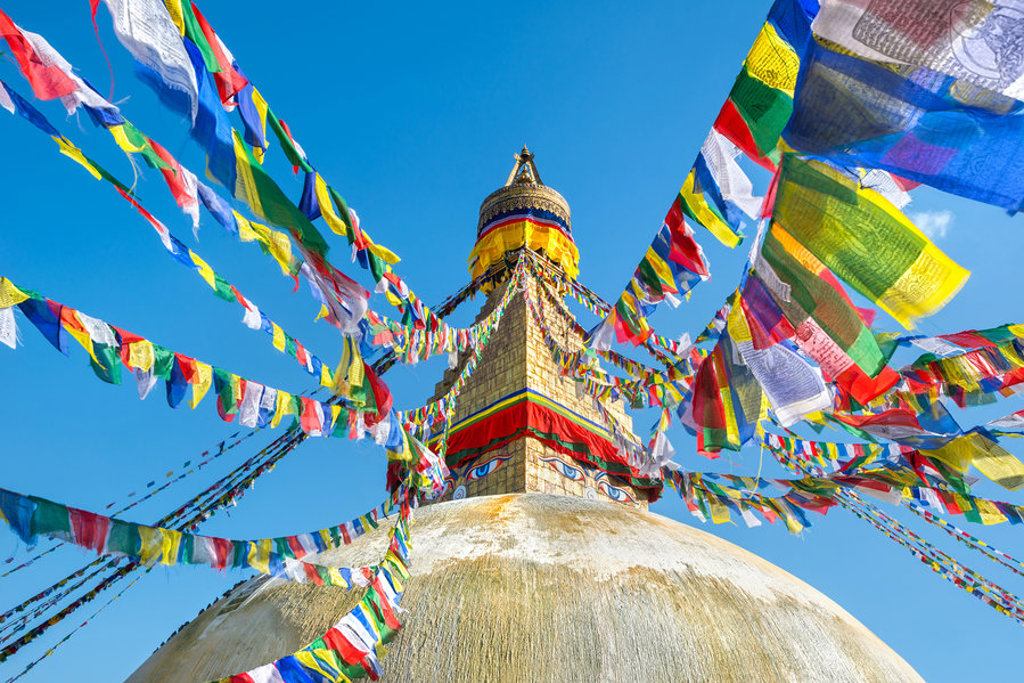 Gouden boeddhistische stoepa met kleurrijke gebedsvlaggen in Kathmandu, Nepal, tijdens de Annapurna Basecamp groepsrondreis.