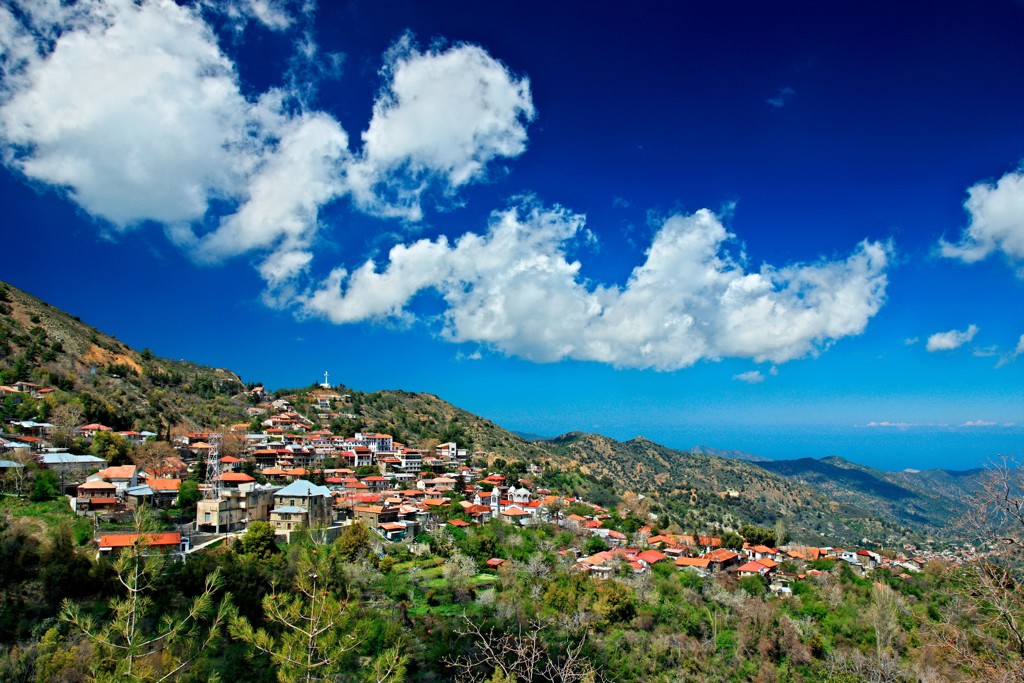 Bergdorp in het Troodosgebergte op Cyprus met rode daken en uitzicht op heuvels en zee.