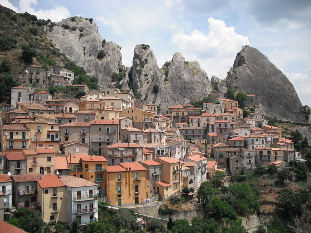 Bergdorp Castelmezzano in Zuid-Italië met kleurrijke huizen en hoge rotsformaties, ideaal voor een wandelvakantie.