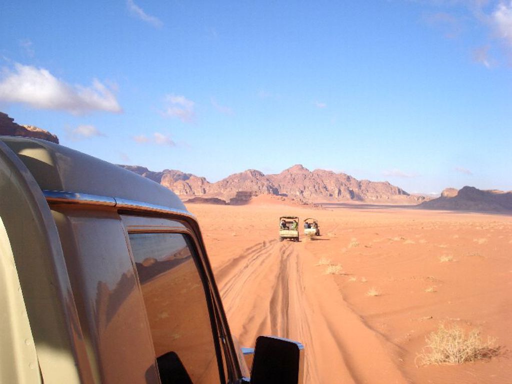 Jeepsafari door de Wadi Rum-woestijn in Jordanië tijdens een familiereis, met rode zandvlaktes en bergen.