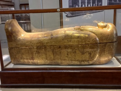 Gouden Egyptische sarcofaag met hiërogliefen in een museumvitrine tijdens Route Egypte.