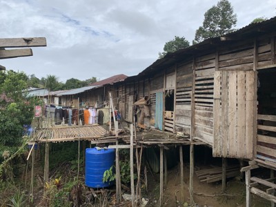 Houten paalwoningen met waslijn in een dorp op Maleisisch Borneo, tijdens de familiereisroute.