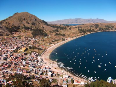 Uitzicht op Copacabana aan het Titicacameer in Bolivia, met baai vol boten en omliggende heuvels.