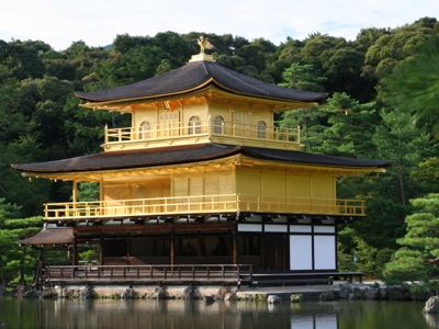 Gouden Paviljoen Kinkaku-ji in Kyoto, Japan, aan een vijver met groene bomen op de achtergrond.
