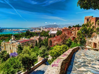Uitzicht vanaf het Alcazaba in Málaga over de stad, haven en kustlijn tijdens een fietstocht in Andalusië.