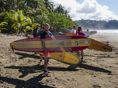 22-35ers met surfboards op het strand in Costa Rica, klaar voor een surfles.