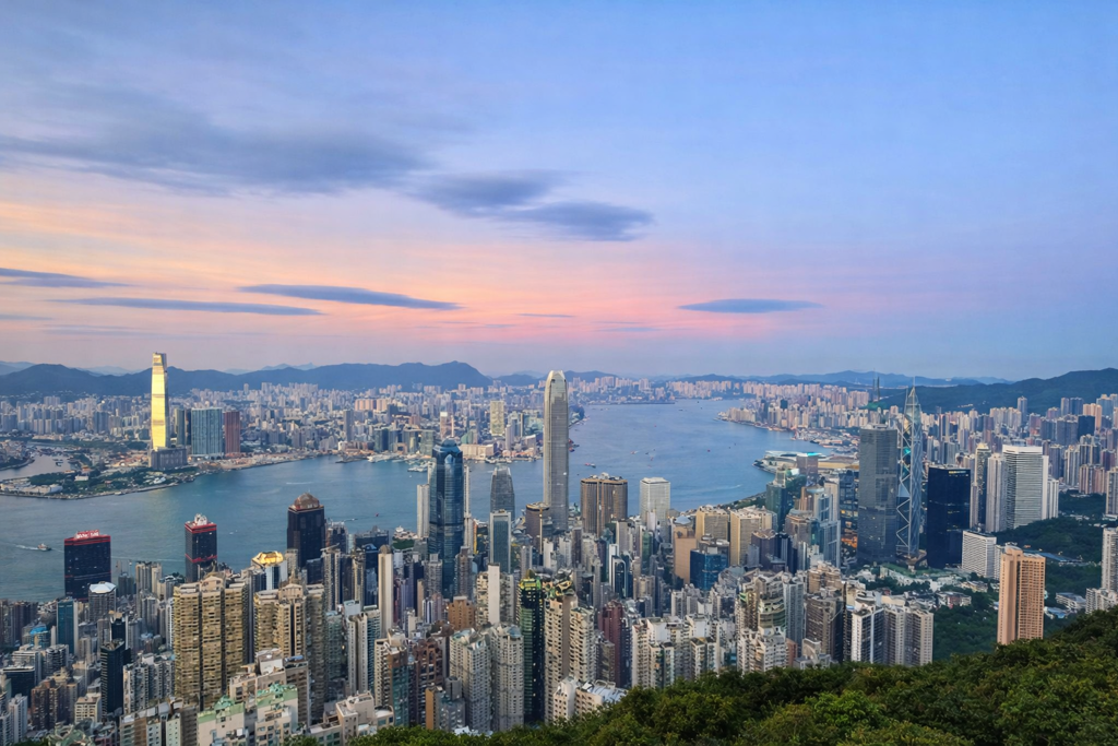 Skyline van Hongkong bij zonsondergang, met Victoria Harbour en wolkenkrabbers.