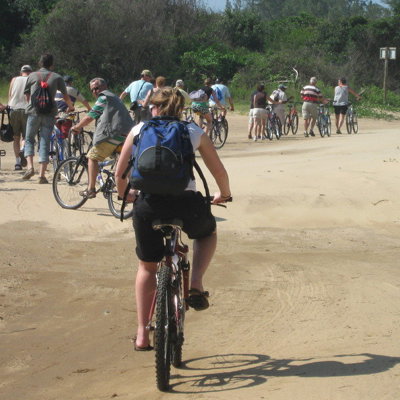 Groep fietsers tijdens een fietstocht op St. Lucia over een zandpad langs groen.