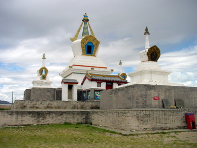 Boeddhistische tempel met witte stoepa’s en gouden details in Mongolië.