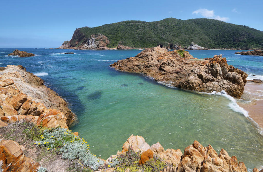Rotsachtige kust en heldere baai langs de Garden Route in Zuid-Afrika tijdens een premium groepsrondreis.