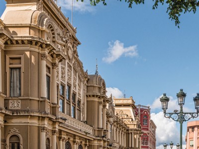 Historische gevels in San José tijdens de Route Costa Rica, met straatlantaarns onder een blauwe lucht.