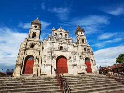 Witte kerk met rode deuren en trappen in León, Nicaragua, op de route Costa Rica en Nicaragua.