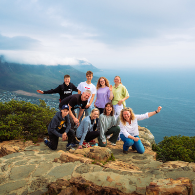 Familiegroep op uitzichtpunt met bergen en oceaan tijdens familiereis Zuid-Afrika en eSwatini.