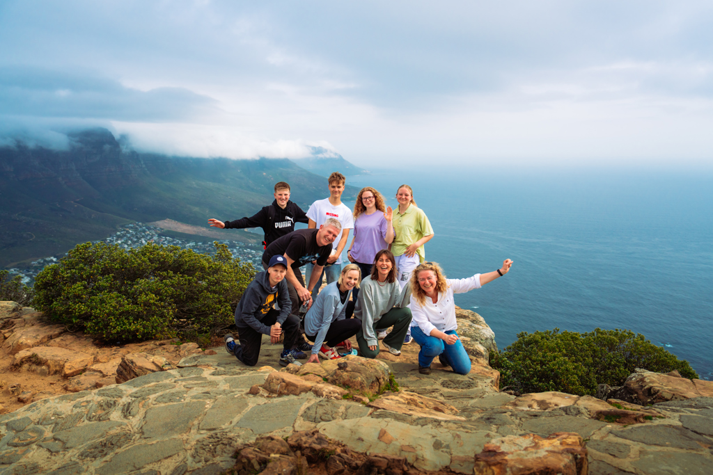 Familiegroep op uitzichtpunt met bergen en oceaan tijdens familiereis Zuid-Afrika en eSwatini.