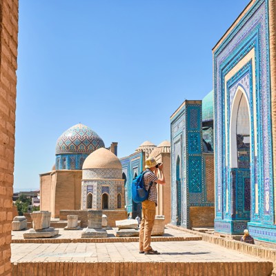 Bezoeker fotografeert blauw betegelde moskee en koepels in Samarkand tijdens groepsrondreis Oezbekistan.