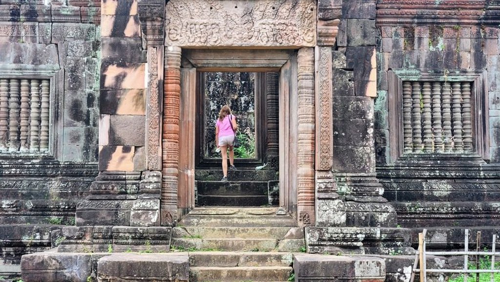 Gouden tempeldak en pagode tussen palmbomen in Laos of Cambodja tijdens een groepsrondreis.