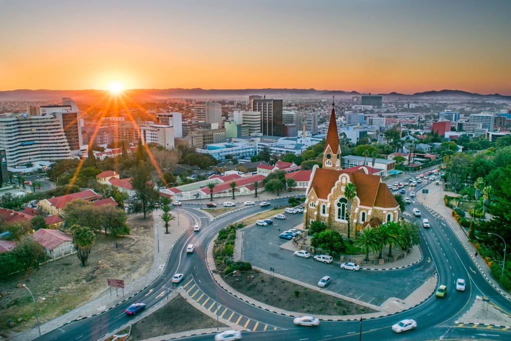 Zonsondergang boven Windhoek met de Christuskirche en de skyline van Namibië tijdens de 22-35ers reis Zuidelijk Afrika.