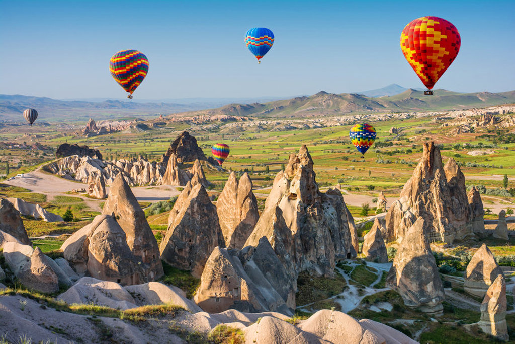 Luchtballonnen boven de rotsformaties van Cappadocië, een hoogtepunt van een groepsrondreis Turkije.