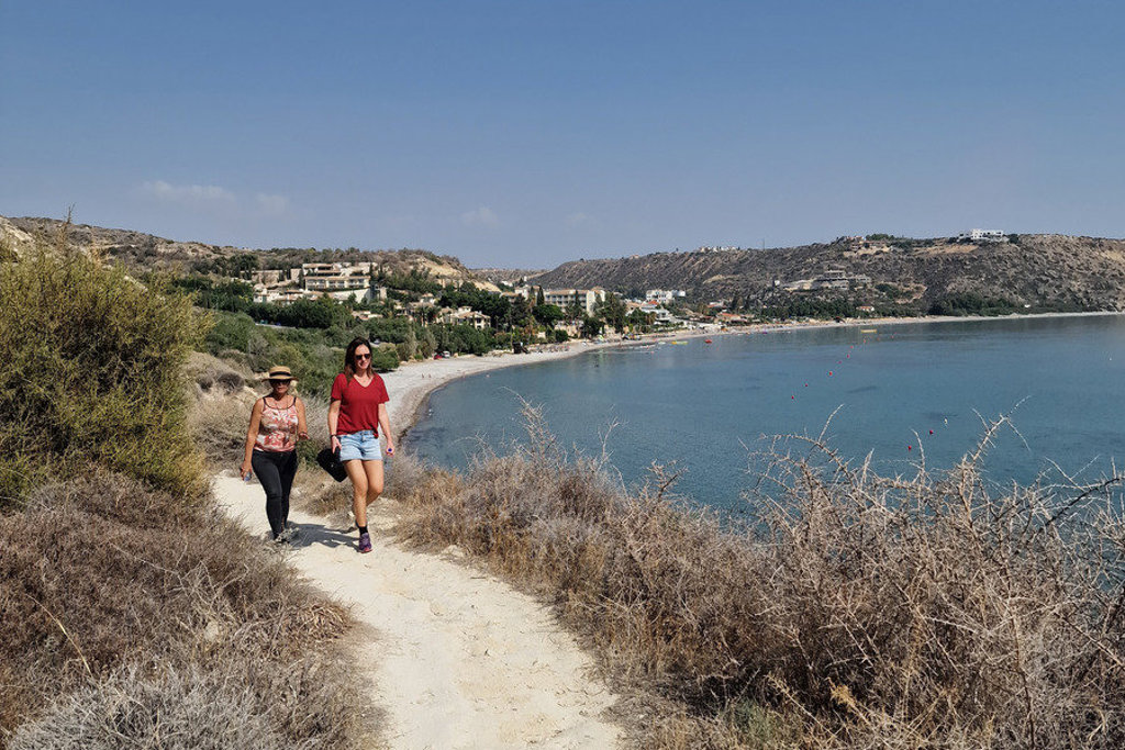 Wandelaars op kustpad langs zee en strand op Cyprus tijdens wandelvakantie.