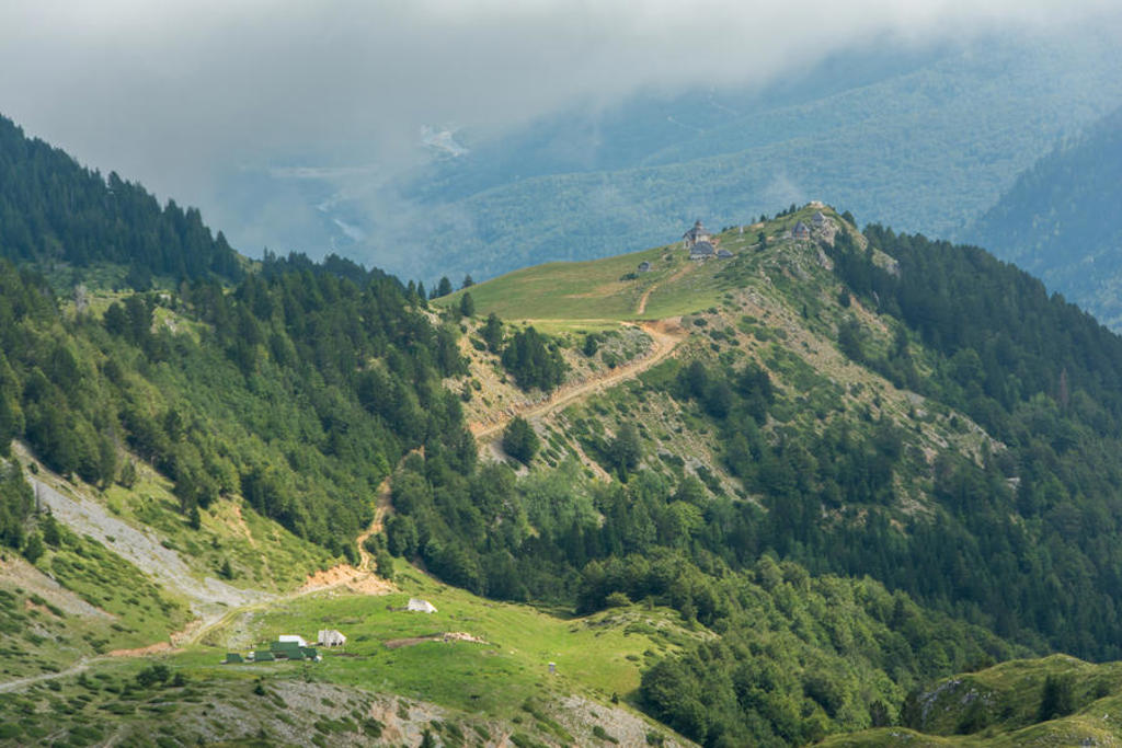 Groene bergkam met wandelpad en berghutten in Montenegro tijdens een 22-35ers reis Balkan.