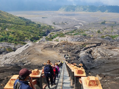 Wandelaars dalen via een lange trap af in het vulkaanlandschap van Bromo op Java, Indonesië.