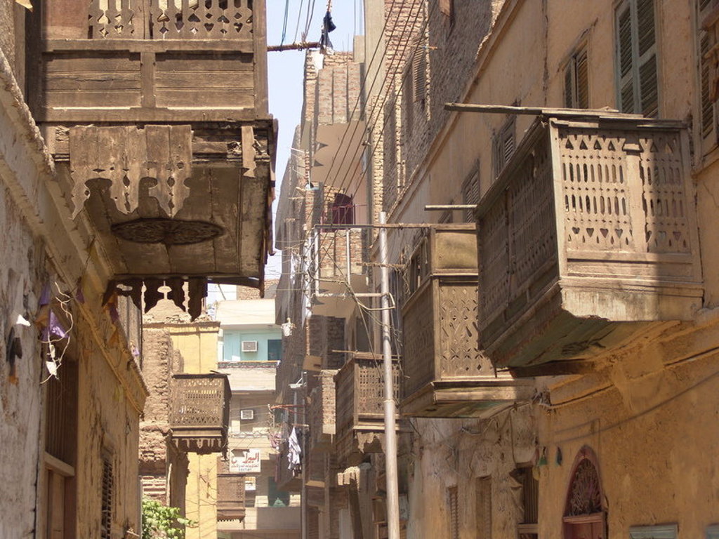 Smalle straat in Caïro met traditionele houten mashrabiya-balkons tijdens de groepsrondreis Egypte Hoogtepunten.