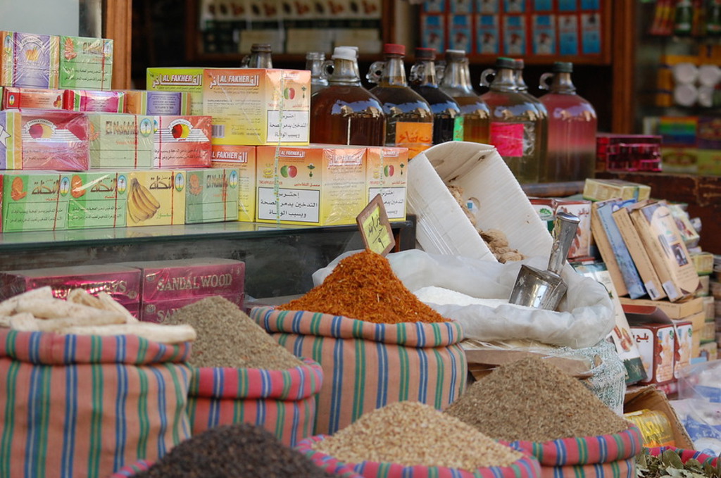 Kruidenkraam in Egypte met specerijen, thee en flessen olie op een markt tijdens een groepsrondreis.
