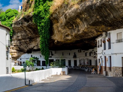 Witte huizen onder een overhangende rotswand in Setenil de las Bodegas, Andalusië.