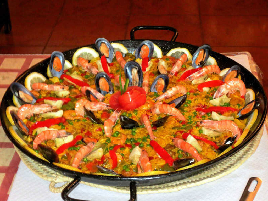Paella met garnalen, mosselen en citroen, typisch Andalusisch gerecht tijdens een wandelvakantie in Spanje.