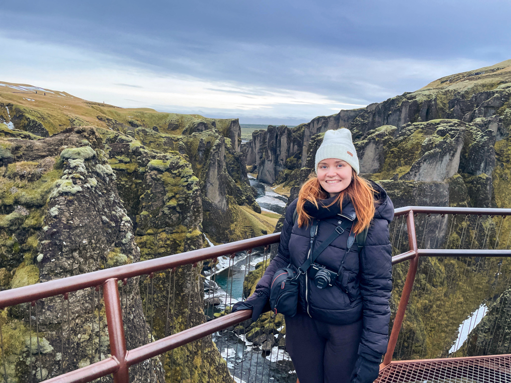 Reiziger bij uitzichtpunt over de Fjaðrárgljúfur-kloof in IJsland tijdens een winter groepsrondreis.