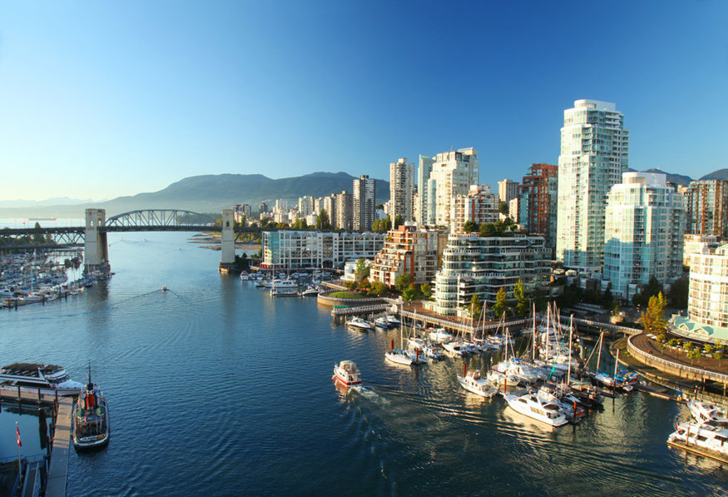 Skyline en jachthaven van Vancouver met Lions Gate Bridge, startpunt van familiereis Canada West.