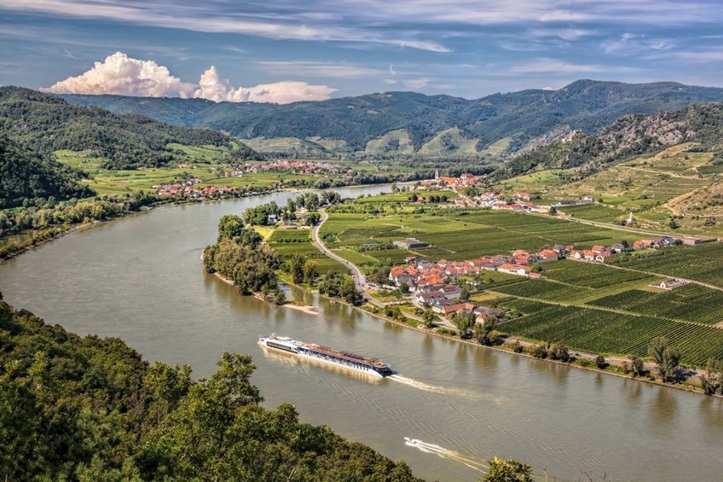 Fietsvakantie langs de Donau met uitzicht op de rivier en groene heuvels in Oostenrijk.