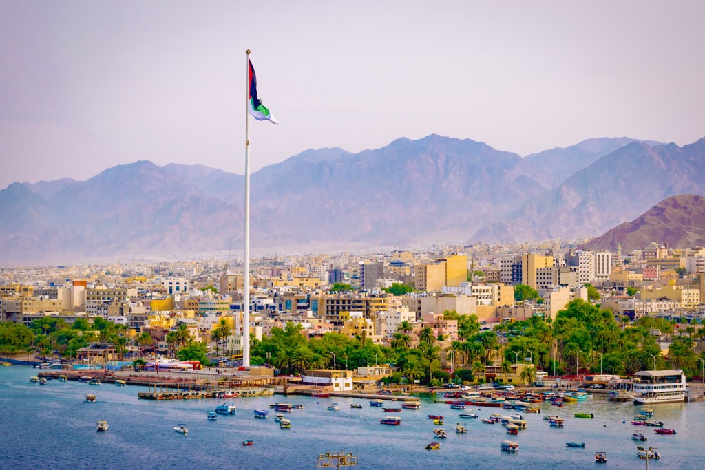 Uitzicht op Aqaba in Jordanië met haven, boten en bergen op de achtergrond.
