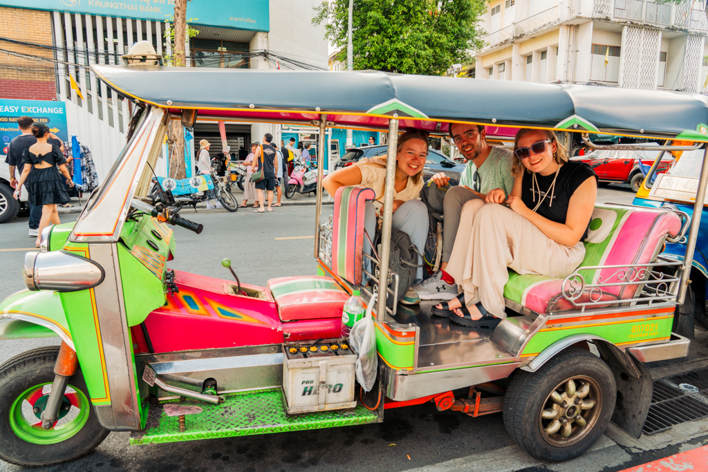 Jongeren in een kleurrijke tuktuk tijdens een 22-35ers reis door Thailand.
