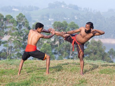 Twee mannen demonstreren Kalaripayattu-vechtkunst tijdens de route door Zuid-India.