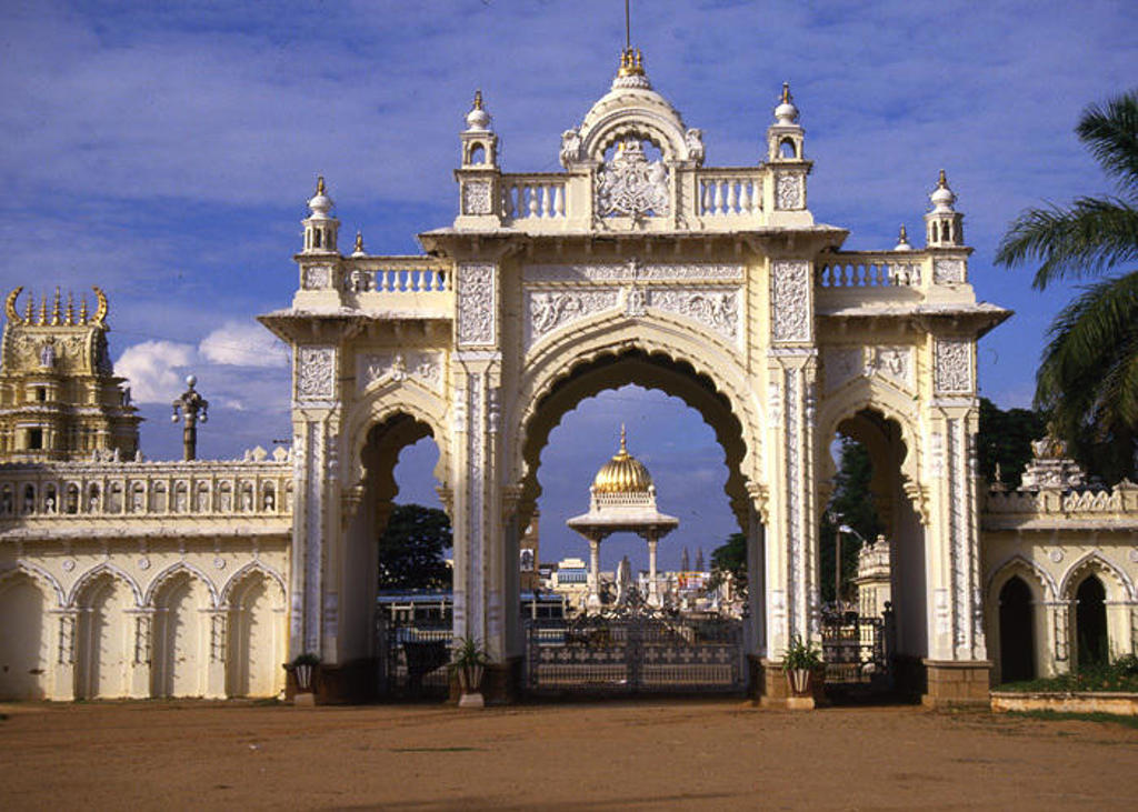 Sierlijke toegangspoort van het Mysore Palace in Zuid-India, met koepel zichtbaar door de boog.