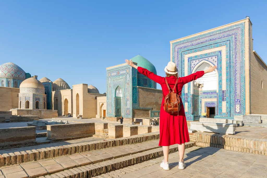Reiziger bij mozaïekgebouwen en koepels in Samarkand tijdens groepsrondreis Oezbekistan.