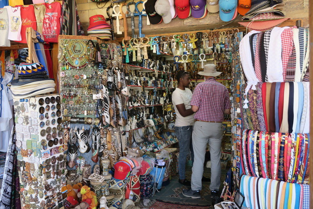 Souvenirwinkel in Egypte met toerist die souvenirs bekijkt tijdens een groepsrondreis.