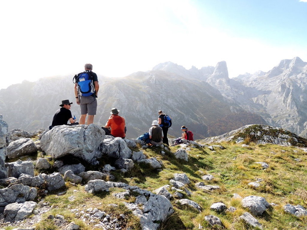 Wandelaars met rugzakken pauzeren op rotsen met uitzicht op de bergen van Picos de Europa in Spanje.