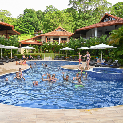 Families genieten van het zwembad bij een lodge in het groene regenwoud van Costa Rica.