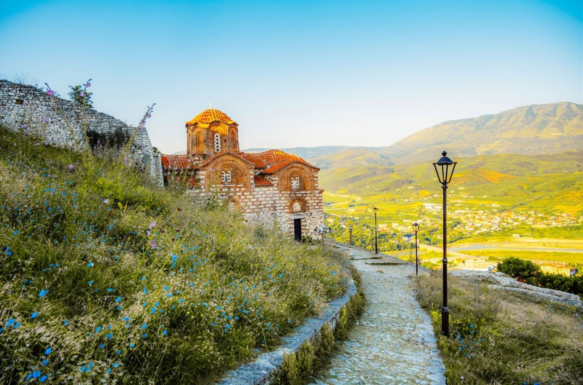 Byzantijnse kerk met rood dak in Berat, Albanië, met uitzicht over de vallei en bergen.