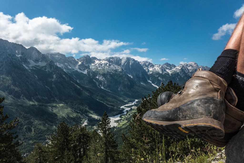 Wandelschoenen met uitzicht op de bergtoppen en vallei van de Peaks of the Balkan.