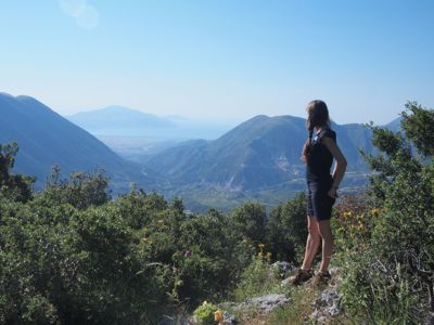 Wandelaar bij uitzichtpunt met panorama over bergen en dal in Albanië, route Albanië, Kosovo en Noord-Macedonië.