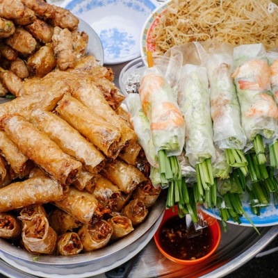 Streetfood in Ho Chi Minhstad met loempia’s, gegrilde spiesjes en verse springrolls op een marktkraam.