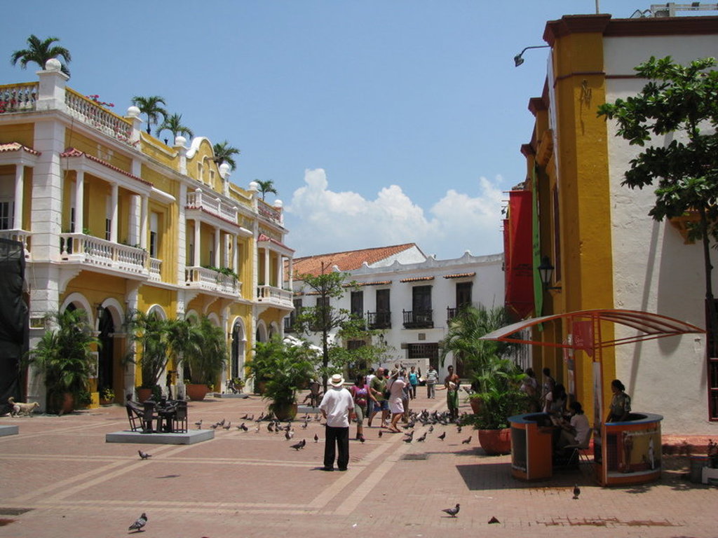 Kleurrijk plein in Cartagena, Colombia, met historische gebouwen en wandelaars tijdens een groepsrondreis.